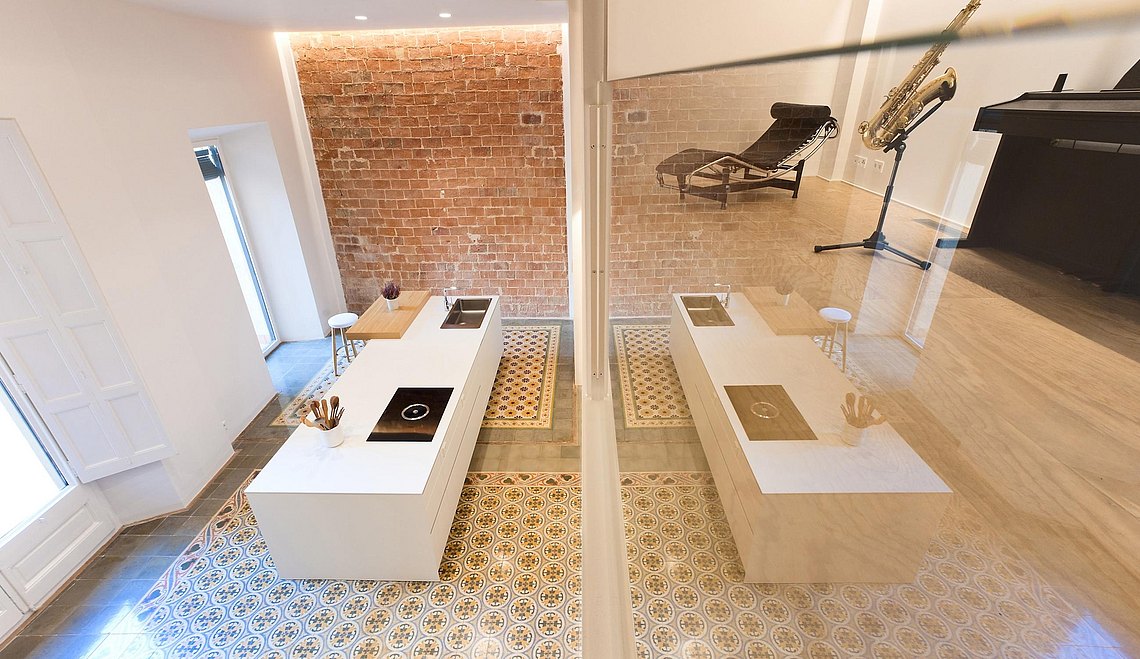 Through the glass wall, on the mezzanine, the piano and the saxophone wait patiently for their moment